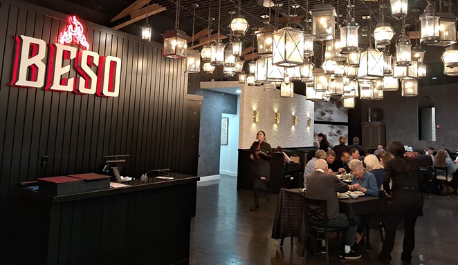 LOFTY INTERIOR: Beso Cocina is quickly becoming known for its glowing red flame symbol and dark interior set off by a constellation of black wrought iron lamps hanging from the ceiling.