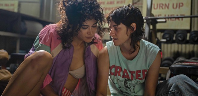 LOVE BURN: Bodybuilder Jackie (Katy O’Brian, left) and gym owner Lou (Kristen Stewart) fall for each other and into a world of violence in Love Lies Bleeding, screening in local theaters.