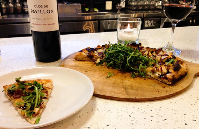 PEAR NECESSITIES: Arugula, bacon, and pear are among the ingredients featured on one of chef Paul Kwong’s wood-fired pizza specials, offered on a rotating basis, at Off Base at Hangar 7 in Lompoc.